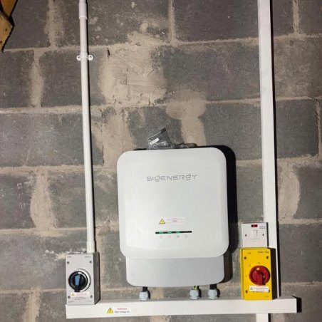 Sigenergy inverter and isolators neatly wired on brickwork